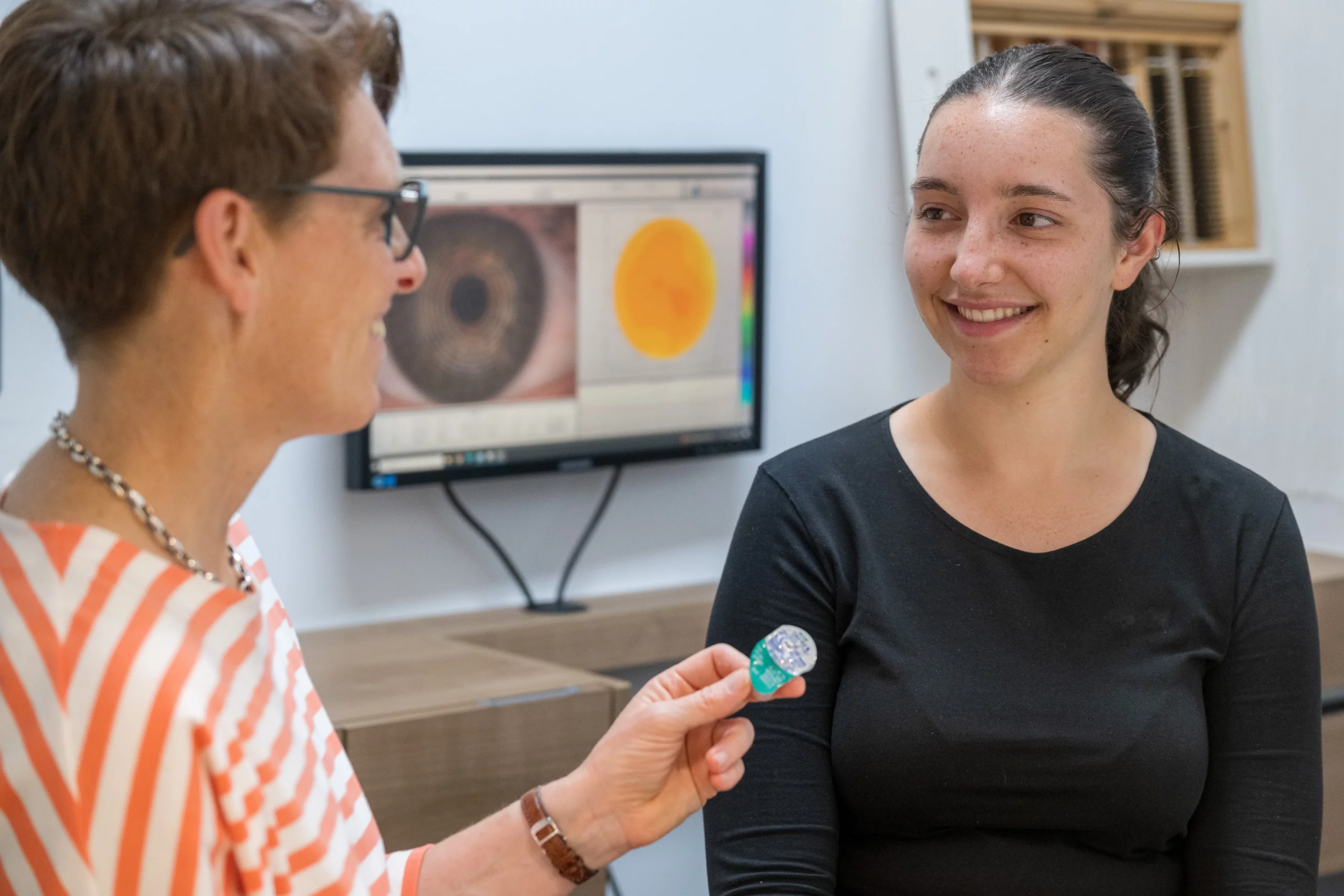 Augenoptikerin berät junge Frau zu Kontaktlinsen