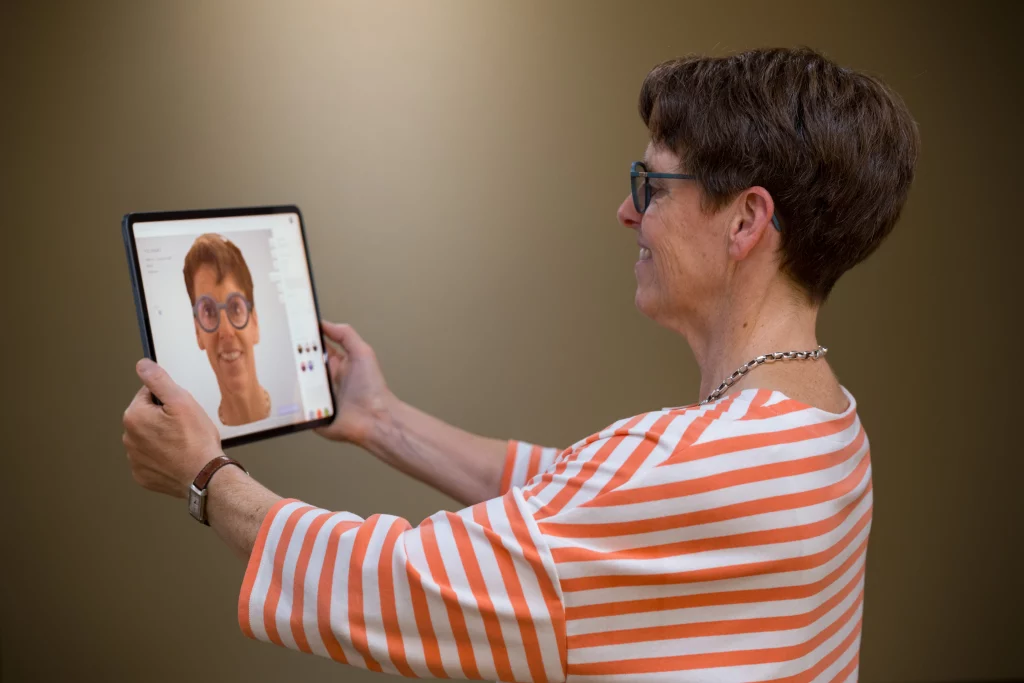 Frau probiert virtuell eine Brille auf einem Tablet an